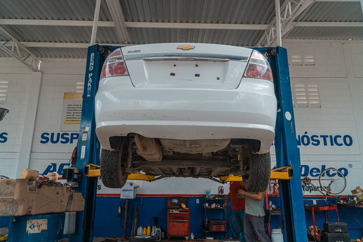 Bras de suspension et soufflet de cardan inspectés sous une voiture levée